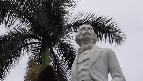 statue of a man under a palm tree