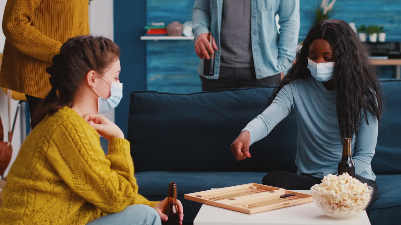 Woman using dice playing backgammon with multiethnic friends