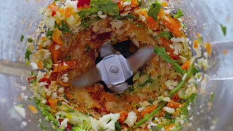 Blender-blades-sliced-vegetables-in-bowl-close-up.-Preparing-tasty-vitamin-food.