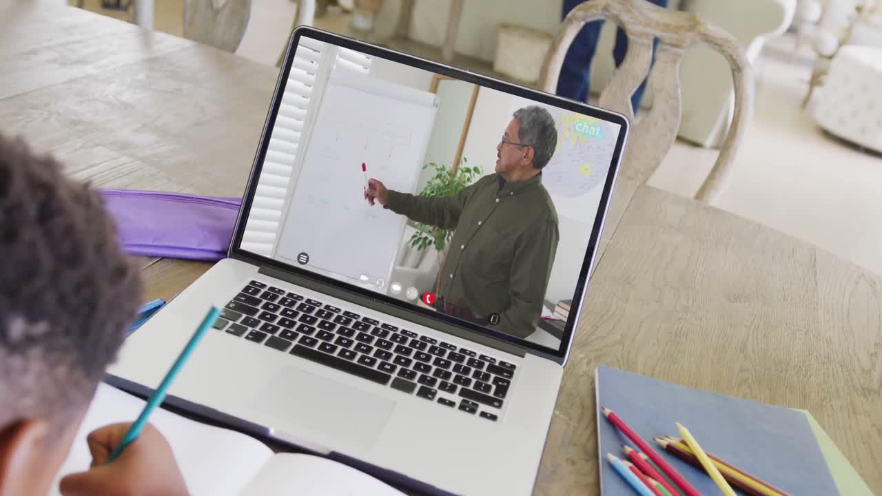 African american boy using laptop for online lesson with biracial male teacher on screen