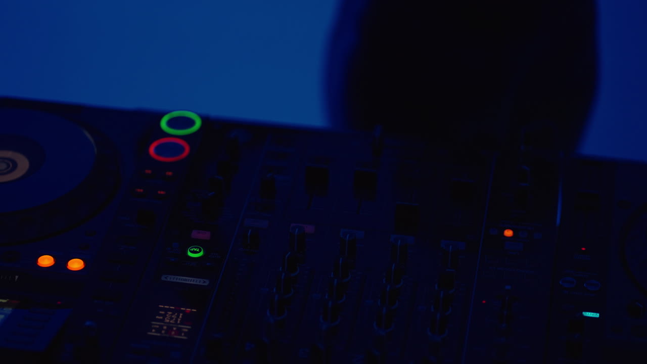 una mujer dj tocando música en un escenario oscuro