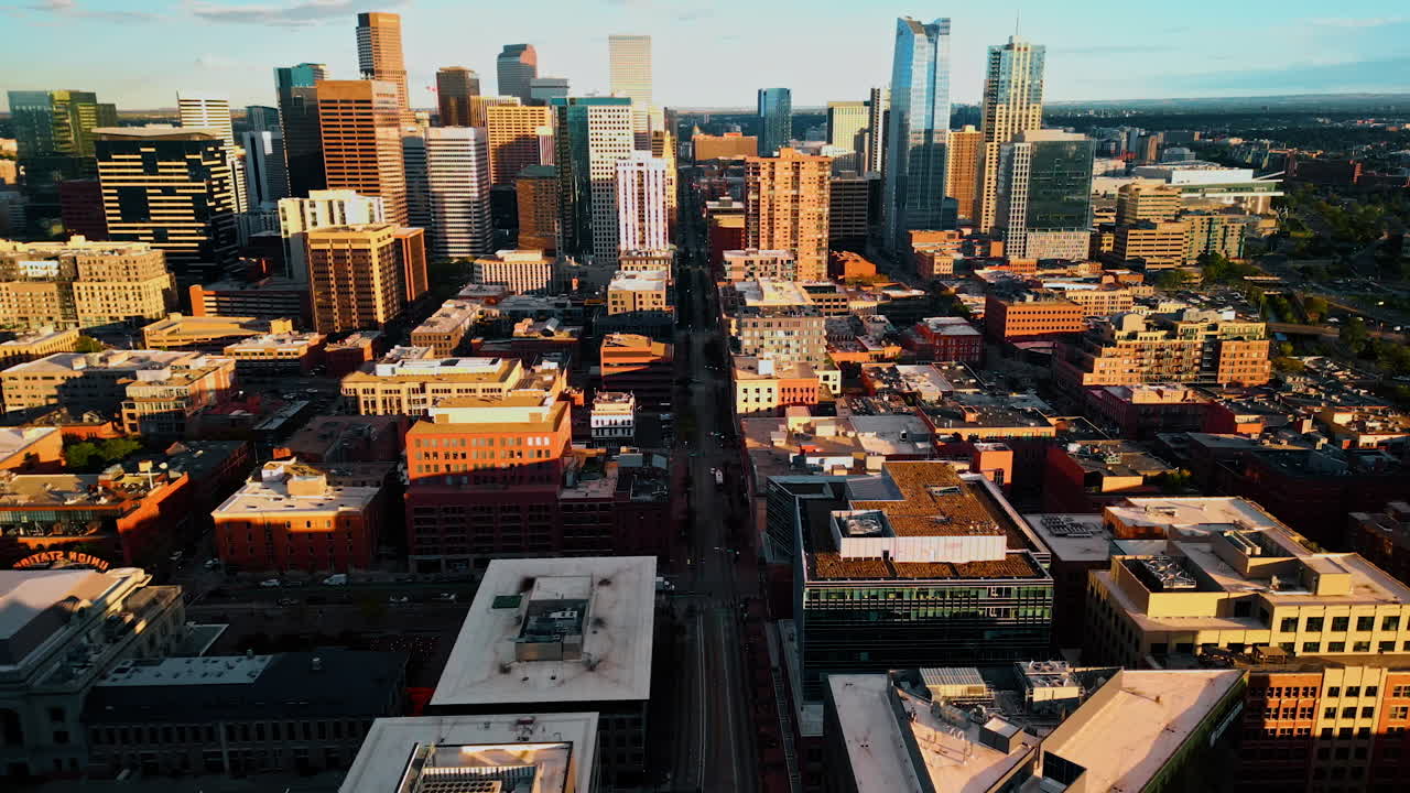 Denver, USA, 28 July 2025: Buildings in the dense cityscape lit by the light of setting sun. Drone flight over Denver, Colorado, USA approaching the high-rises in the downtown