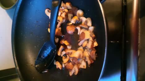 sizzling sliced mushrooms in frying pan. vertical video