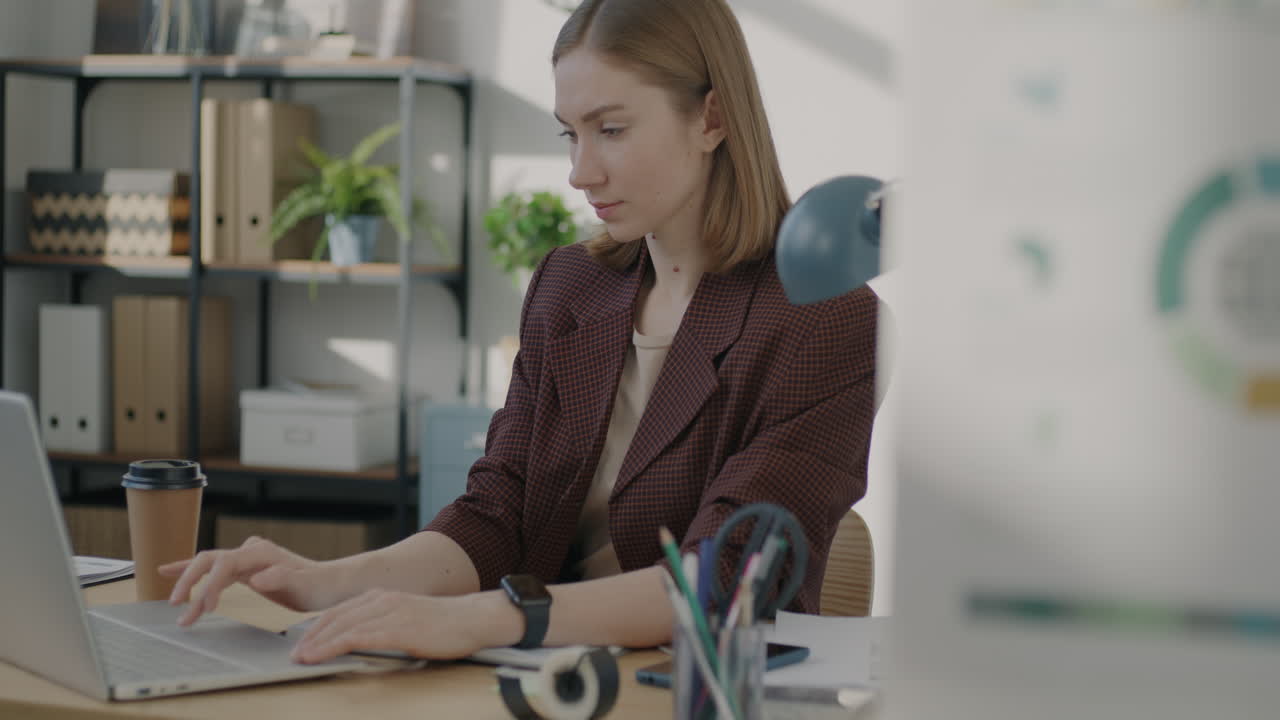 женщина работает на ноутбуке в современном офисе