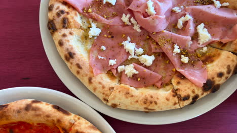 pizze tradizionali italiane, pizza ai peperoni e pizza alla mortadella con pistacchi e mozzarella burrata, colpo 4k