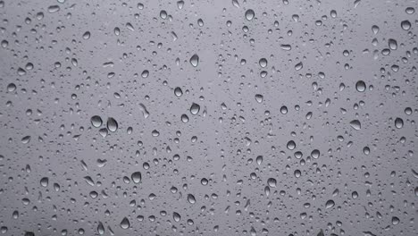 raindrops on blurry glass window - rainy day concept - close up