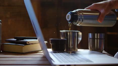 hombre tomando café mientras usa computadora portátil mientras está en casa 4k