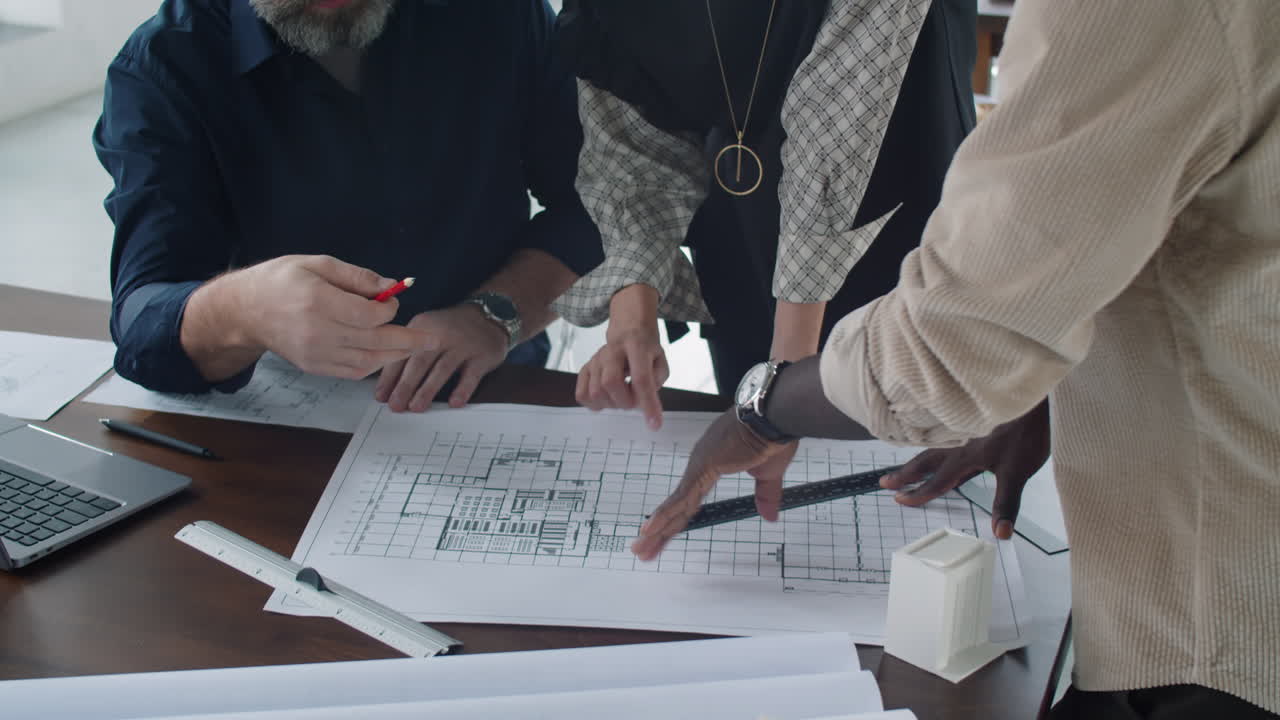 arquitectos multiétnicos discutiendo el plan de planta en la oficina