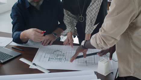 arquitectos multiétnicos discutiendo el plan de planta en la oficina