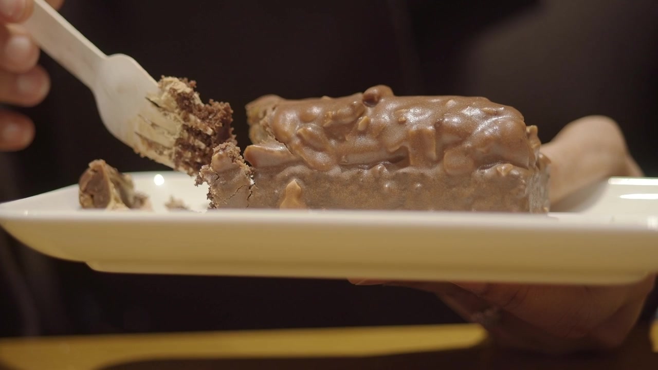 Close-up of a Hand Cutting a Piece of Chocolate Cake with a Fork