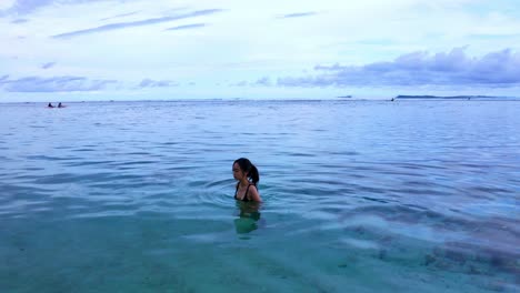 asian tourist on turquoise water of gunung payung beach in bali, indonesia