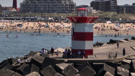 beach scene with lighthouse and people in the netherlands