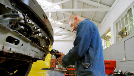 mechanic using grinding machine on a car 4k