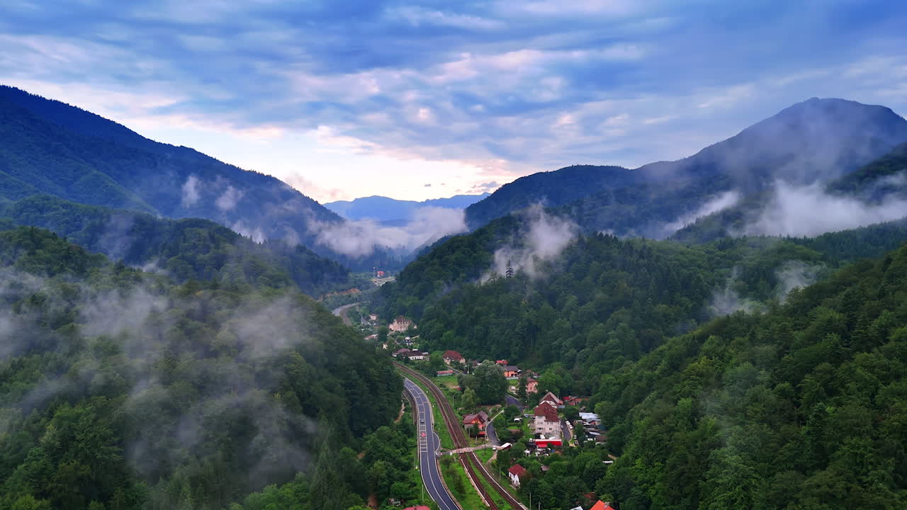 Mountain valley with misty clouds in Romania. Misty clouds hang over a scenic mountain valley and village in the Carpathians of Romania