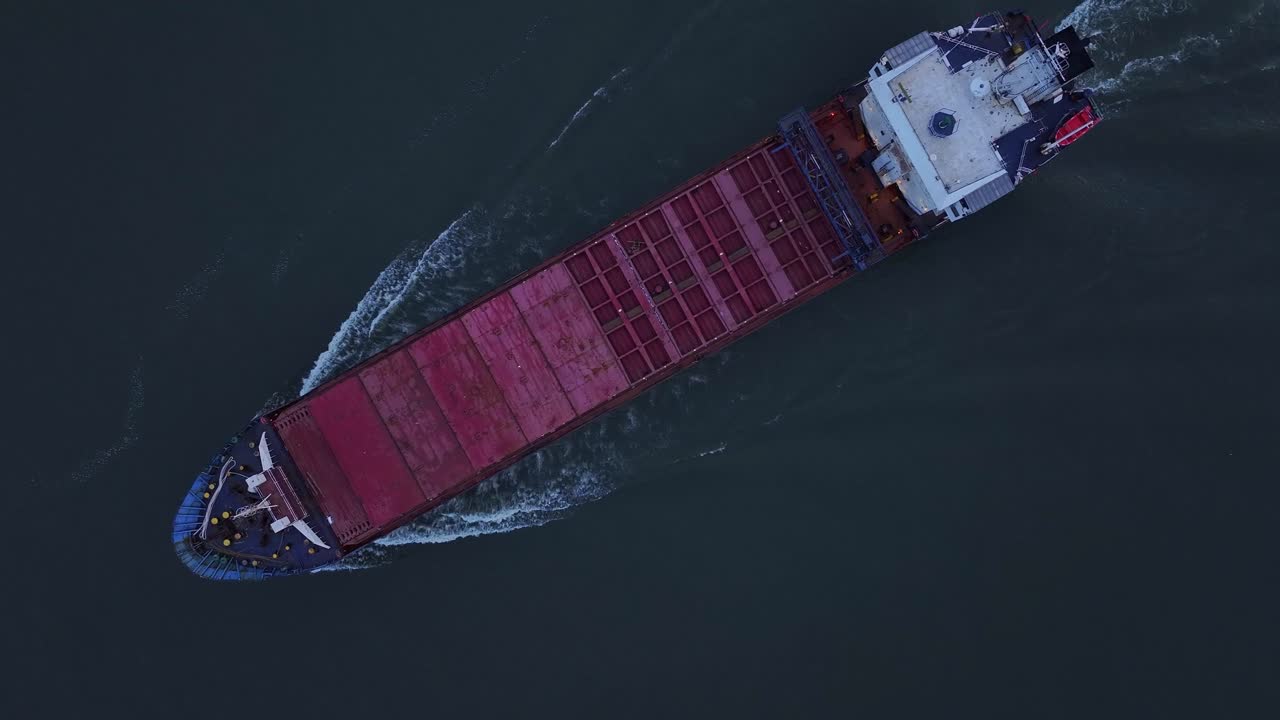 el buque de carga rix union deja atrás un rastro blanco y espumoso mientras viaja a lo largo del río en zwijndrecht, países bajos.