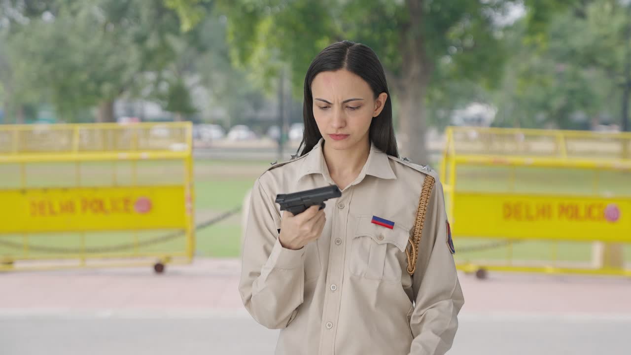 oficial de policía indio chequeando una pistola