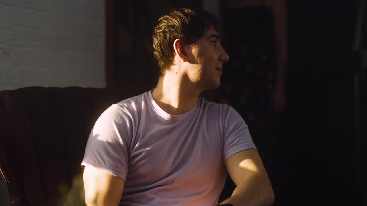 Guy watches girlfriend dance laughs and smiles to himself