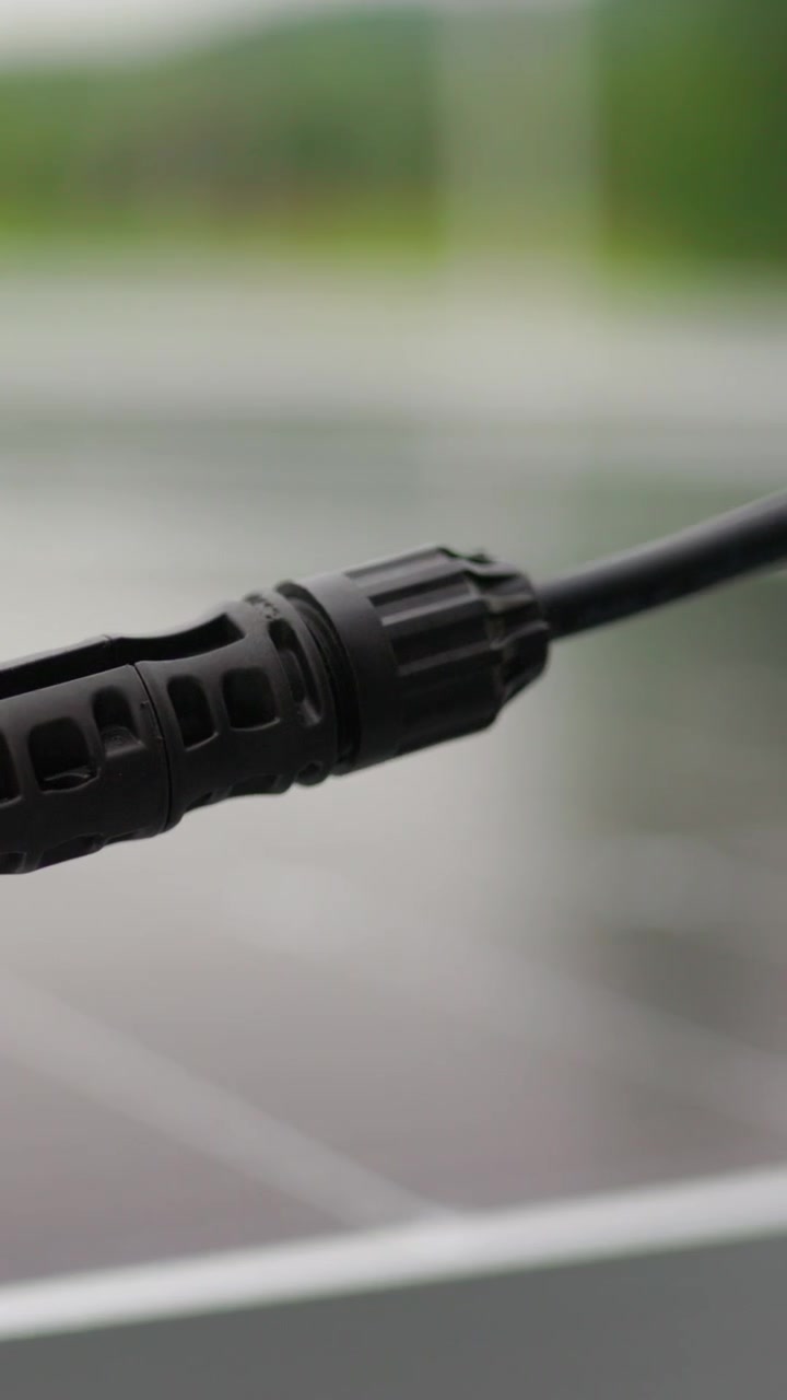 A closeup shot of a black cable connector against a blurred background showcasing its intricate