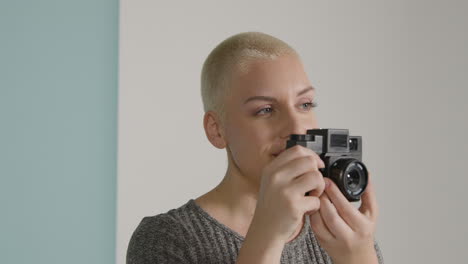 Tracking-shot-orbiting-around-female-photographer-posing-with-vintage-camera-01