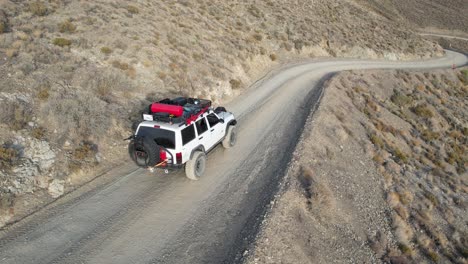 Ein-Weißer-Jeep-Cherokee,-Der-Einen-Dreck-Hinunterfährt