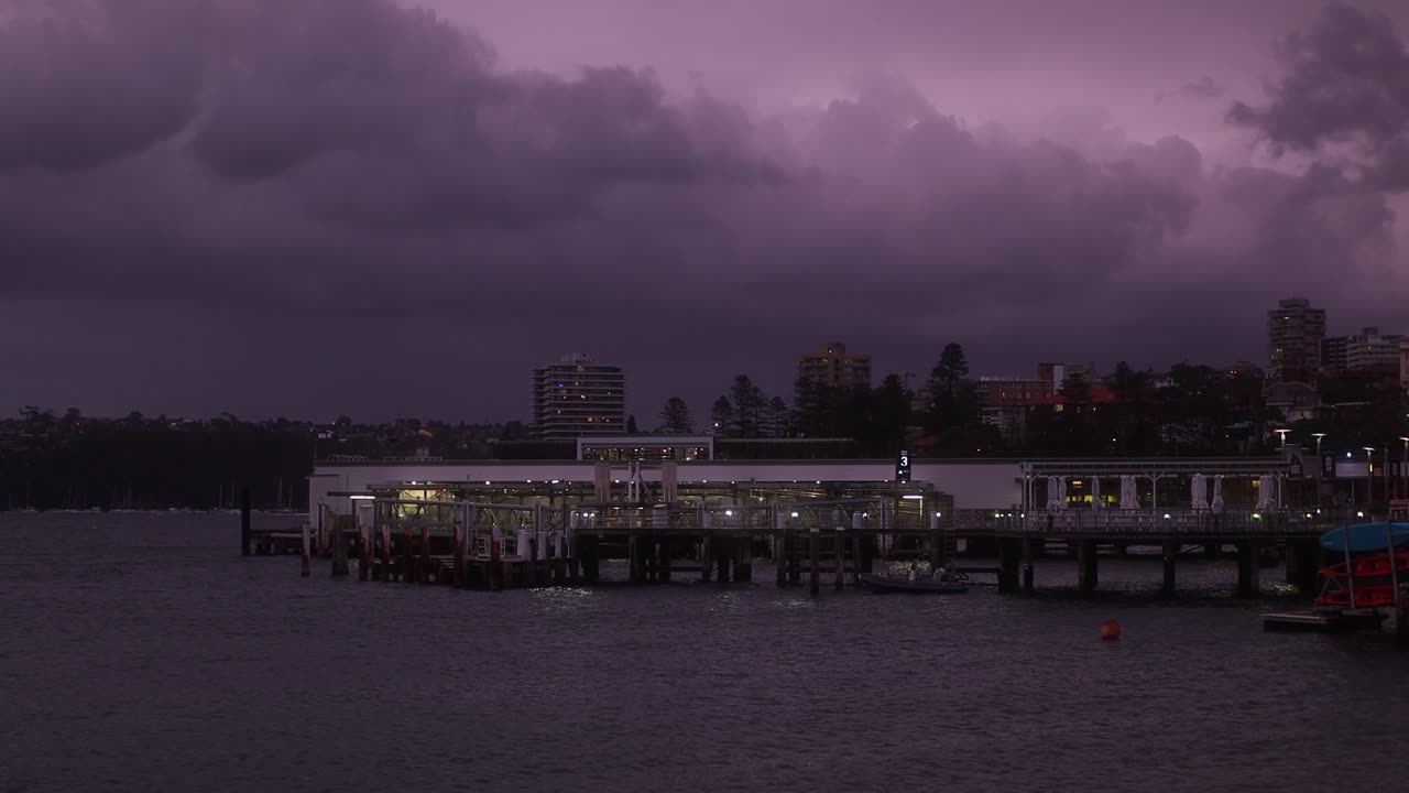 Witness the dramatic beauty of a stormy La Ni&ntilde;a sky, painted in hues of purple, over Manly Wharf