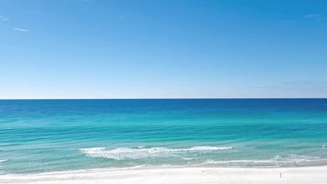 clear caribbean waters of the gulf with white sand beach in foreground.