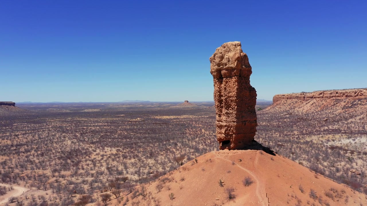 Široký letecký přílet k skalnímu útvaru Vingerklip v Namibii, dron se vznáší nad pouštní krajinou