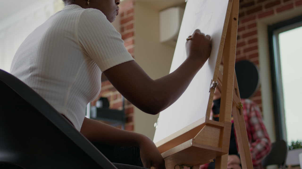 Donna afroamericana che usa una matita per disegnare uno schizzo di un vaso
