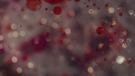 abstract pequeñas burbujas líquidas claras y salpicaduras rojas de sangre movimiento bokeh movimiento textura de fondo