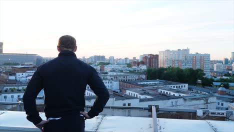 man on rooftop overlooking city