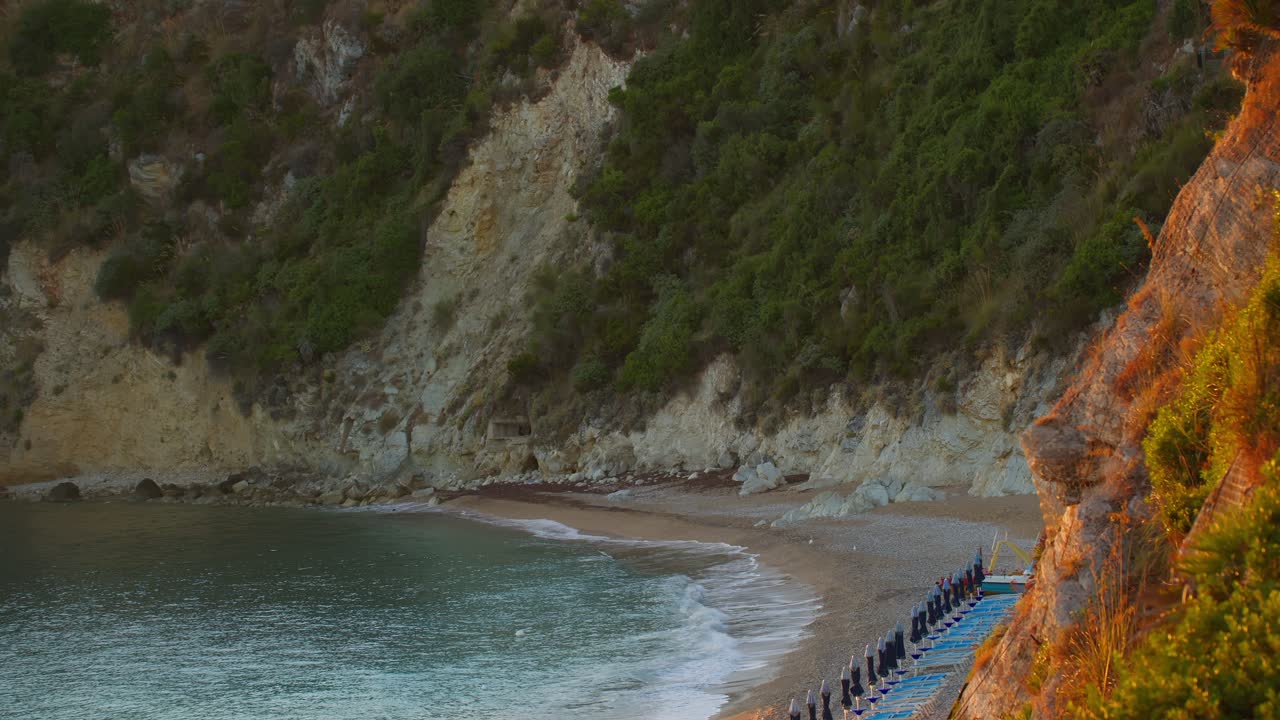 High angle sunrise shot of empty beach at Guidaloca Beach (Spiaggia di Guidaloca) in Castellammare del Golfo, Sicily, Italia, with calm and peaceful ocean