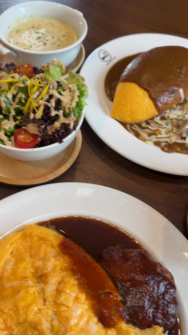 Varios platos occidentales emplatados con arroz con tortilla, filete de hamburguesa, ensalada y salsas cremosas, en vista cenital.