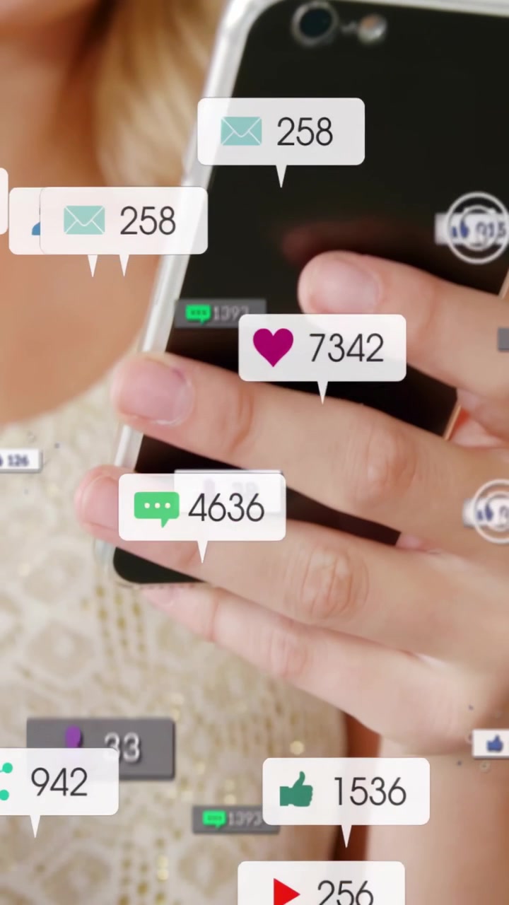 Vertical video: Woman holding phone shifting grip, ping causing like icons growing for marketing