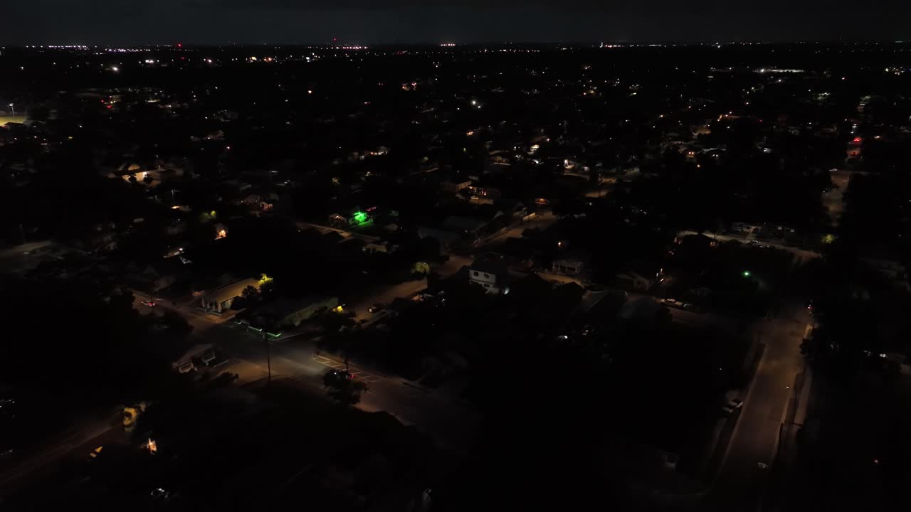 Tampa neighborhood at night. Aerial backwards shot. Housing area and homes in suburb district. Driving cars on street in quiet area. Top down. Florida, United States.