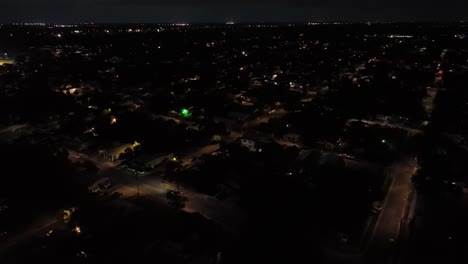 tampa neighborhood at night. aerial backwards shot. housing area and homes in suburb district. driving cars on street in quiet area. top down. florida, united states.