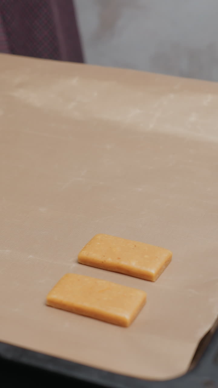 dama preparándose para colocar pedazos de masa recién cortados en la bandeja de horneado en el horno, rodeada de herramientas de panadería, atmósfera de cocina, rodillo, cortadores de galletas, lista para hornear galletas caseras