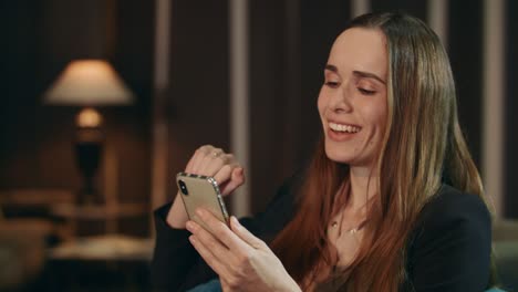 Mujer-Sonriente-Haciendo-Videollamadas-En-El-Teléfono-Móvil-En-La-Sala-De-Estar