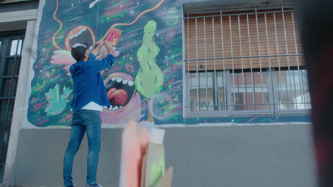 Street Artist Drawing Fantasy Graffiti on the Wall