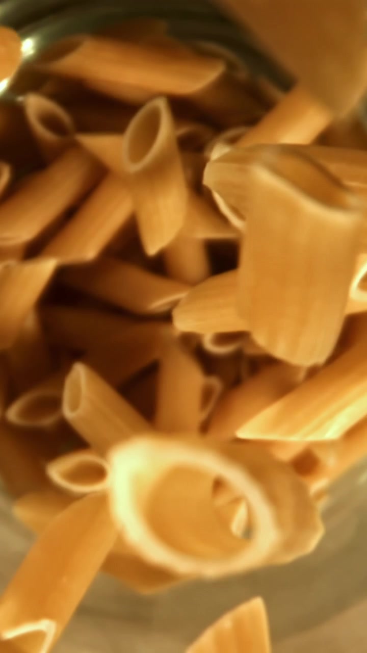 Penne che cadono in un contenitore al rallentatore