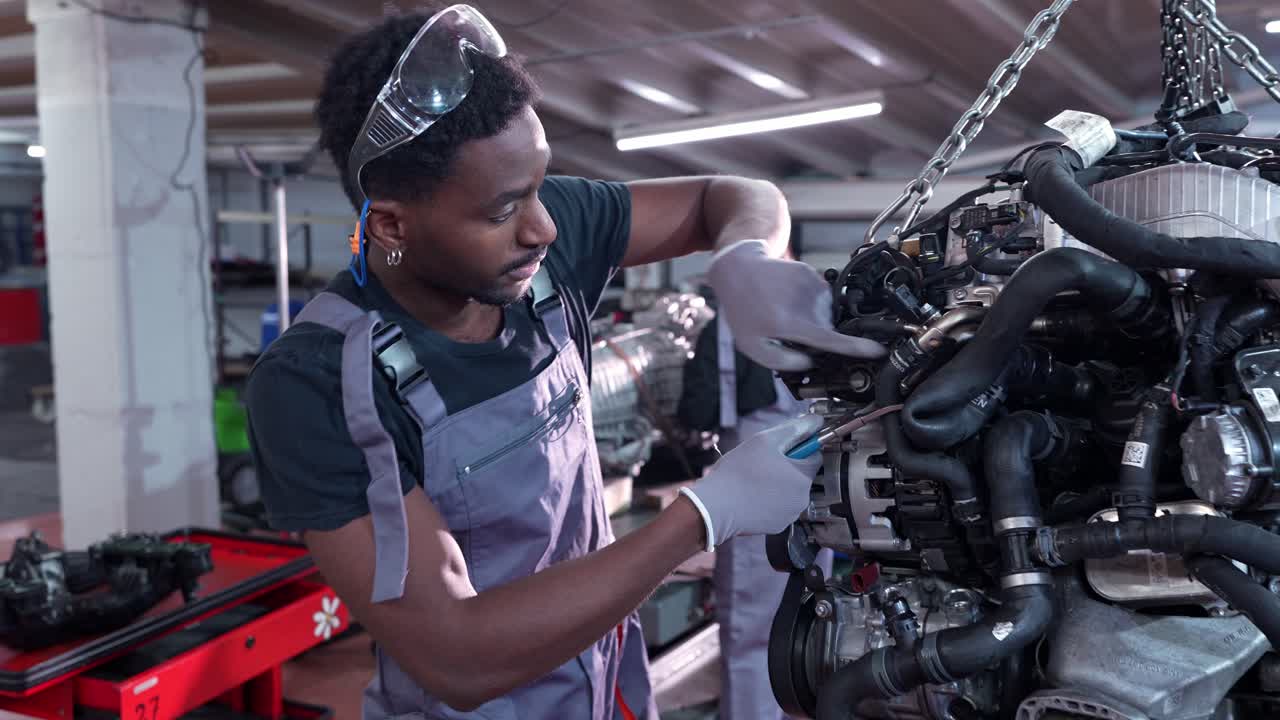 Mechanic working on car engine in a workshop