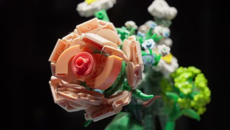 colorful plastic toy flower with black background, rack focus close-up