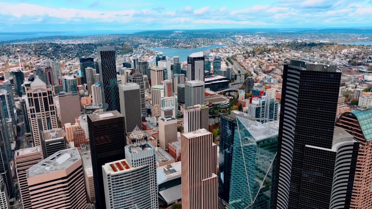 Drone subindo ao longo dos impressionantes arranha-céus no centro da cidade americana. Ampla vista da cidade de Seattle, Washington, EUA, de cima, durante o dia.