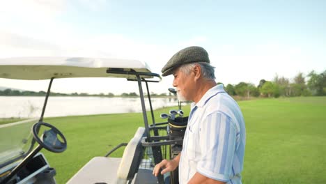 4k portrait of asian senior man golfer standing on golf course at summer sunset.