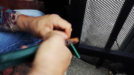 manos del hombre quitando el aislamiento del cable eléctrico usando pinzas