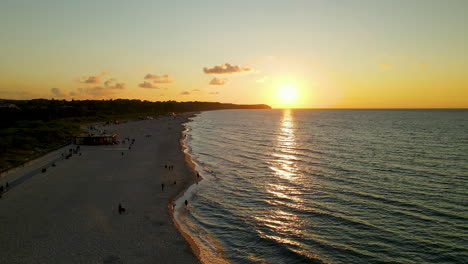 Wladyslawowo-Strand-Mit-Einheimischen-Und-Touristen,-Die-Den-Wunderschönen-Sonnenuntergang-Im-Ozean-Bewundern