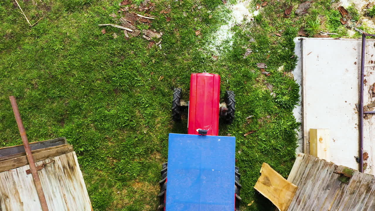 persona que se sube a un pequeño tractor para trabajar en el campo, vista aérea de arriba hacia abajo