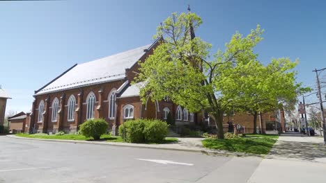 a milton church with trees in front on a sunny summer day