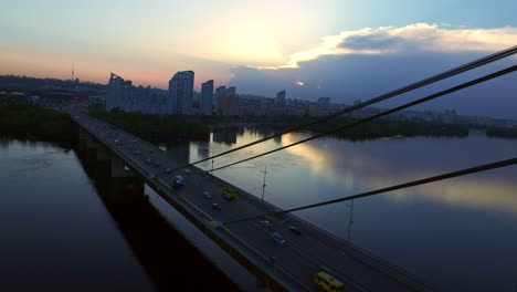 car on river bridge in evening city. aerial view evening city landscape