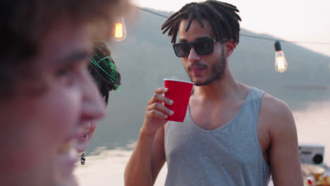 young man and woman dancing and smiling at lake party