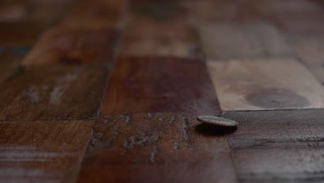 Coin-Drop-On-Wooden-Floor-Showing-Tails